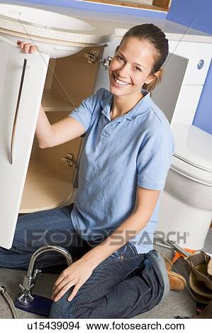 Plumber working on sink smiling View Large Photo Image Picture - Plumber working on sink smiling. Fotosearch