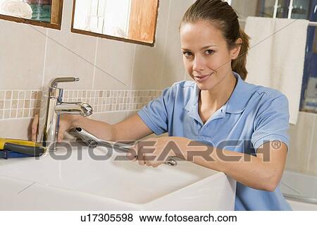 Plumber working on sink smiling View Large Photo Image Stock Photo - Plumber working on sink smiling. Fotosearch