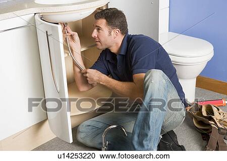 Plumber working on sink View Large Photo Image Stock Image - Plumber working on sink. Fotosearch