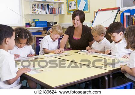Picture - Students in class with teacher reading. Fotosearch
