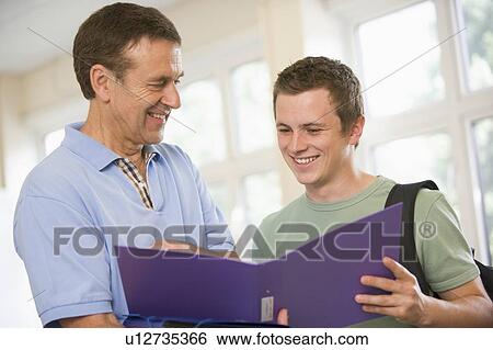 Teacher in corridor talking to student with notebooks View Large Photo Image Stock Photograph - Teacher in corridor talking to student with notebooks. Fotosearch