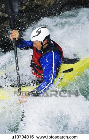 Kayaker in rapids coming over waterfall (selective focus) View Large Photo Image Stock Photograph - Kayaker in rapids coming over waterfall (selective focus). Fotosearch