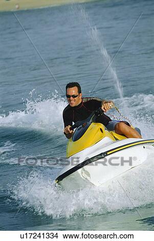 Picture - Man jet skiing and smiling (selective focus). Fotosearch
