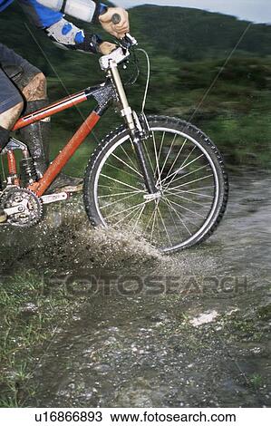 Stock Image - Man outdoors on trails riding bicycle (selective focus). Fotosearch