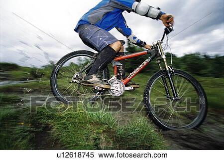 Man outdoors on trails riding bicycle (selective focus) View Large Photo Image Stock Photography - Man outdoors on trails riding bicycle (selective focus). Fotosearch