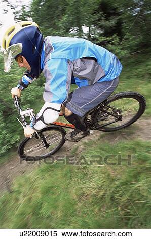 Stock Photography - Man outdoors on trails riding bicycle (selective focus). Fotosearch