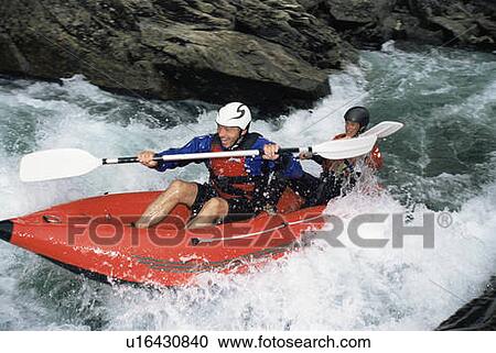 Stock Image - Two kayakers in rapids smiling (selective focus). Fotosearch
