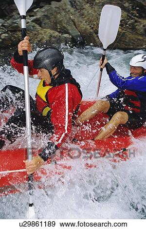 Two kayakers rowing in rapids and smiling (selective focus) View Large Photo Image Stock Photo - Two kayakers rowing in rapids and smiling (selective focus). Fotosearch