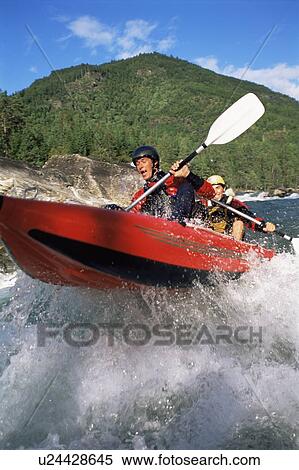 Stock Photography - Two kayakers rowing in rapids (selective focus). Fotosearch