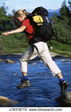 Woman outdoors hiking in scenic location jumping over water (selective focus) View Large Photo Image Stock Image - Woman outdoors hiking in scenic location jumping over water (selective focus). Fotosearch