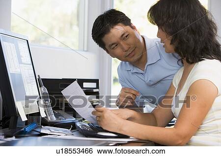 Couple in home office with computer and paperwork View Large Photo Image Stock Photograph - Couple in home office with computer and paperwork. Fotosearch
