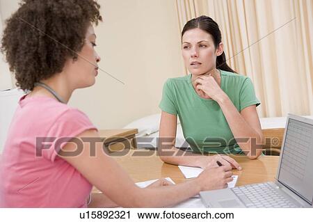 Doctor with laptop and woman in doctor's office frowning View Large Photo Image Stock Image - Doctor with laptop and woman in doctor's office frowning. Fotosearch