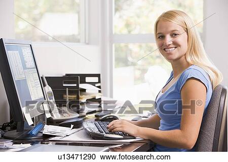 Woman in home office using computer and smiling View Large Photo Image Stock Image - Woman in home office using computer and smiling. Fotosearch
