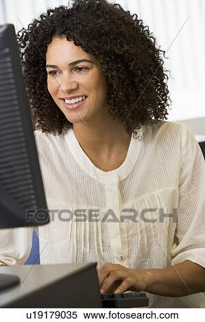 Woman sitting at a computer terminal typing (high key) View Large Photo Image Stock Photography - Woman sitting at a computer terminal typing (high key). Fotosearch