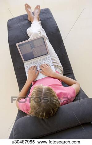Stock Photography - Woman sitting in chair using laptop. Fotosearch