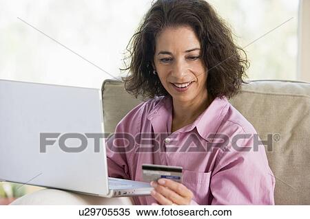 Woman with a laptop computer making an online purchase with credit card View Large Photo Image Stock Photography - Woman with a laptop computer making an online purchase with credit card. Fotosearch