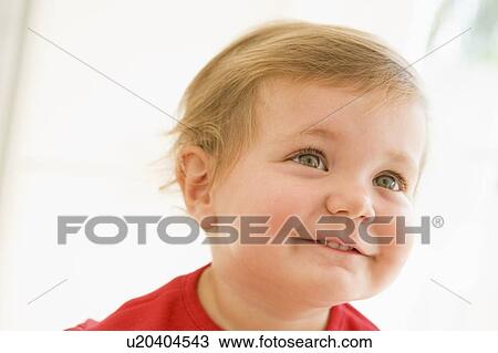 Stock Image - Baby indoors smiling. Fotosearch