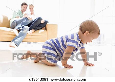 Couple in living room with baby smiling View Large Photo Image Stock Image - Couple in living room with baby smiling. Fotosearch