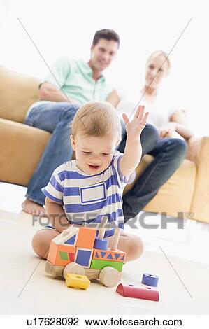 Couple in living room with baby smiling View Large Photo Image Stock Image - Couple in living room with baby smiling. Fotosearch