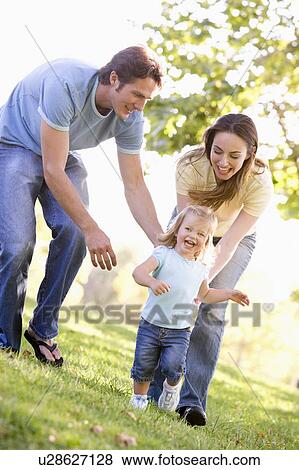 Stock Photo - Family running outdoors smiling. Fotosearch
