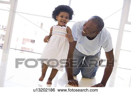 Father and daughter indoors playing and smiling View Large Photo Image Stock Photograph - Father and daughter indoors playing and smiling. Fotosearch