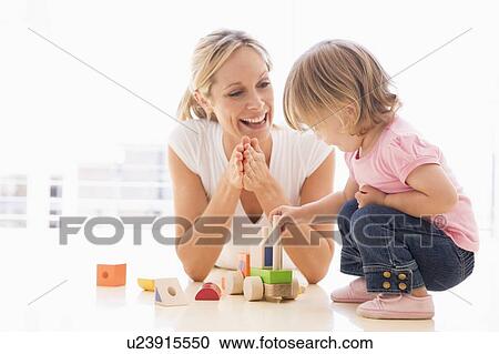 Mother and daughter indoors playing and smiling View Large Photo Image Stock Image - Mother and daughter indoors playing and smiling. Fotosearch