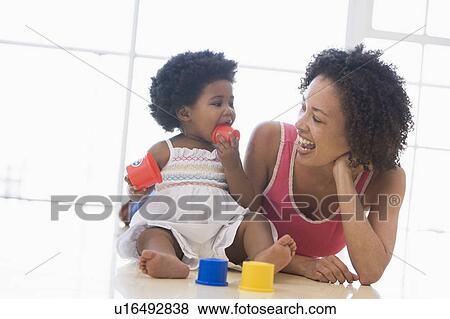 Mother and daughter indoors playing and smiling View Large Photo Image Stock Photo - Mother and daughter indoors playing and smiling. Fotosearch