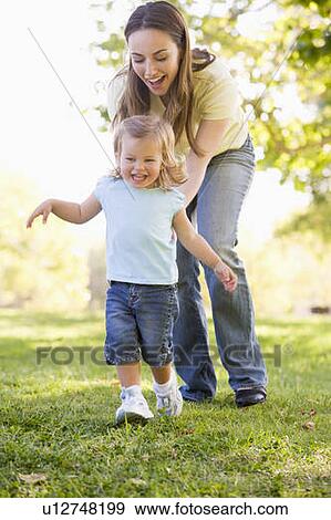 Mother and daughter playing outdoors smiling View Large Photo Image Stock Photo - Mother and daughter playing outdoors smiling. Fotosearch