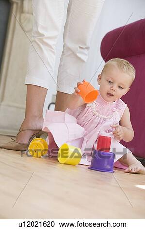 Stock Image - Mother in living room with baby playing. Fotosearch