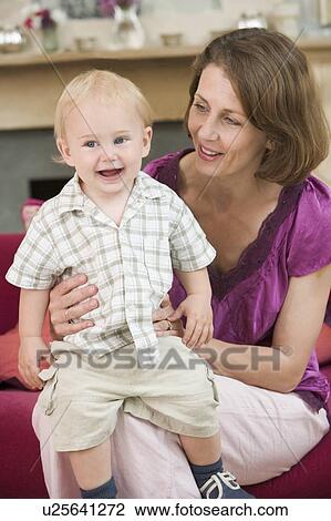 Mother in living room with baby smiling View Large Photo Image Stock Image - Mother in living room with baby smiling. Fotosearch