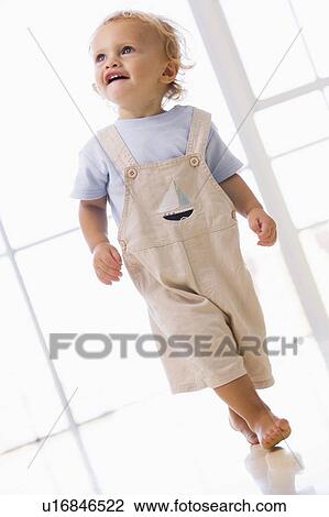 Young boy walking indoors smiling View Large Photo Image Stock Image - Young boy walking indoors smiling. Fotosearch