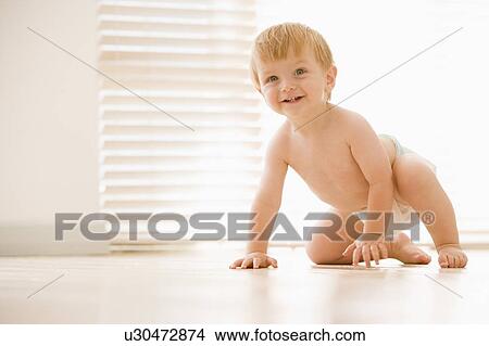 Picture - Baby crawling indoors smiling. Fotosearch