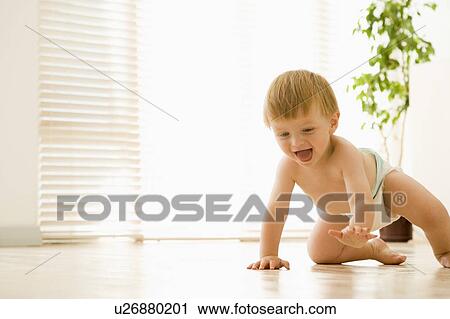 Stock Image - Baby crawling indoors smiling. Fotosearch