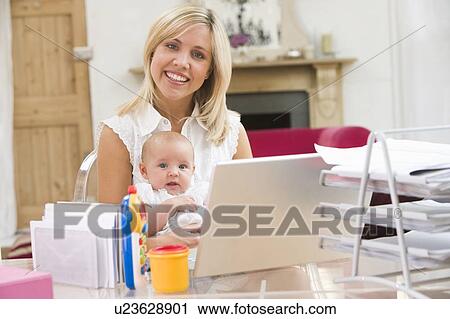 Mother and baby in home office with laptop View Large Photo Image Stock Image - Mother and baby in home office with laptop. Fotosearch