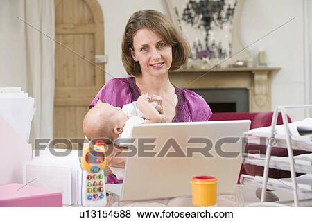 Mother and baby in home office with laptop View Large Photo Image Stock Photo - Mother and baby in home office with laptop. Fotosearch