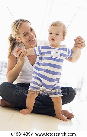 Stock Photo - Mother and baby indoors playing and smiling. Fotosearch