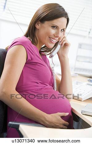 Pregnant woman at work using telephone smiling View Large Photo Image Stock Image - Pregnant woman at work using telephone smiling. Fotosearch