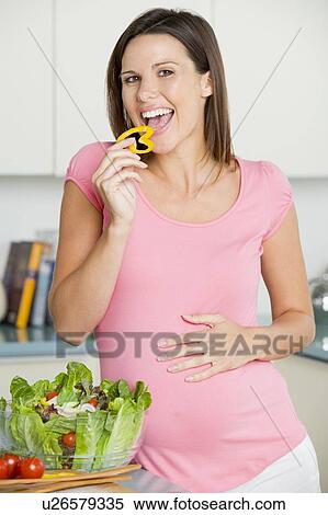 Pregnant woman in kitchen making a salad and smiling View Large Photo Image Stock Photography - Pregnant woman in kitchen making a salad and smiling. Fotosearch