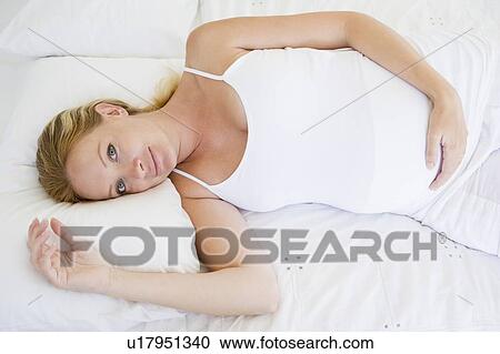 Pregnant woman lying in bed smiling View Large Photo Image Stock Image - Pregnant woman lying in bed smiling. Fotosearch