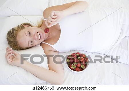 Pregnant woman lying in bed with bowl of strawberries smiling View Large Photo Image Stock Image - Pregnant woman lying in bed with bowl of strawberries smiling. Fotosearch