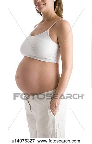 Stock Photo - Pregnant woman with belly exposed smiling. Fotosearch