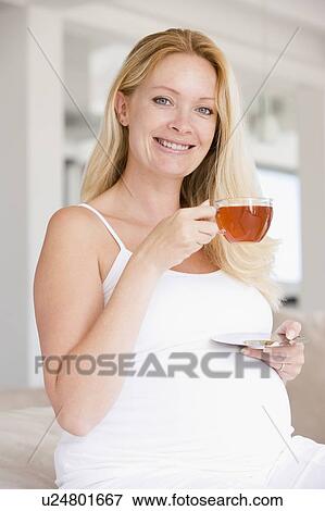 Pregnant woman with cup of tea smiling View Large Photo Image Stock Photo - Pregnant woman with cup of tea smiling. Fotosearch