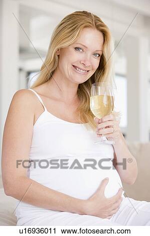 Pregnant woman with glass of white wine smiling View Large Photo Image Stock Image - Pregnant woman with glass of white wine smiling. Fotosearch