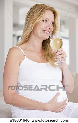 Pregnant woman with glass of white wine smiling View Large Photo Image Stock Image - Pregnant woman with glass of white wine smiling. Fotosearch