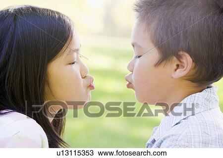 Brother and sister outdoors with eyes closed puckering up View Large Photo Image Stock Image - Brother and sister outdoors with eyes closed puckering up. Fotosearch