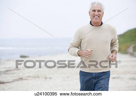 Man at the beach running and smiling View Large Photo Image Stock Photography - Man at the beach running and smiling. Fotosearch