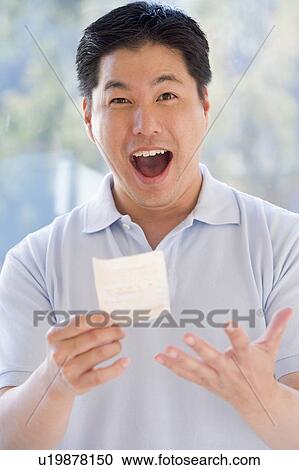 Man with winning lottery ticket excited and smiling View Large Photo Image Stock Image - Man with winning lottery ticket excited and smiling. Fotosearch