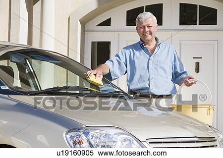 Stock Photography - Senior man washing car outside his home. Fotosearch