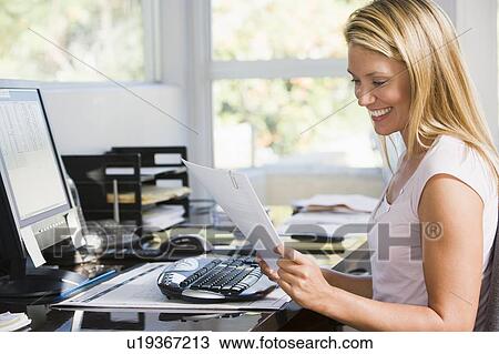 Woman in home office with computer and paperwork smiling View Large Photo Image Stock Image - Woman in home office with computer and paperwork smiling. Fotosearch