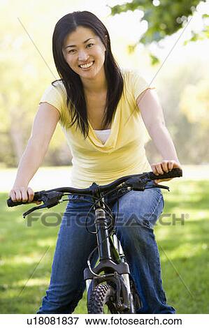Stock Photo - Woman on bicycle smiling. Fotosearch
